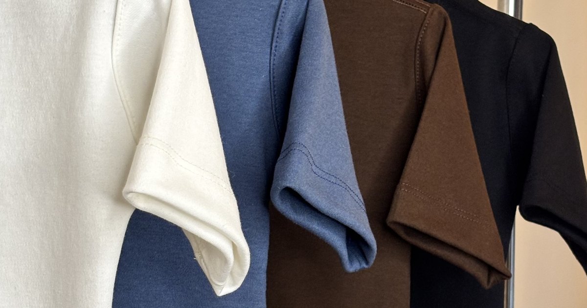 Blusas infantis Noma Mini em marfim, índigo, marrom e preto penduradas lado a lado