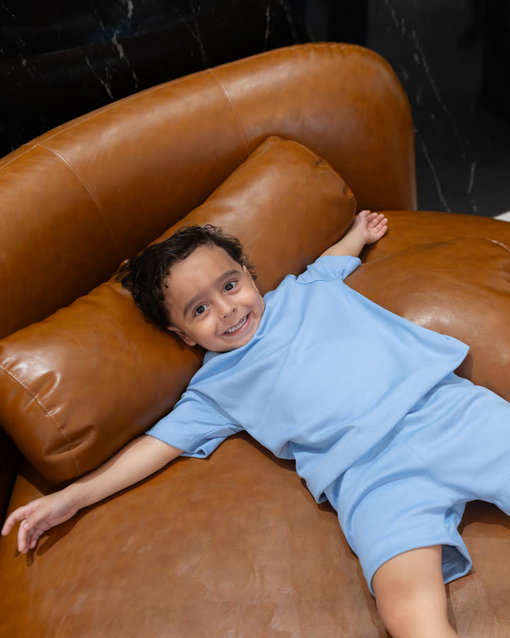 Menino deitado no sofá com o Conjunto Oversize Banim, cor Azul Serenity