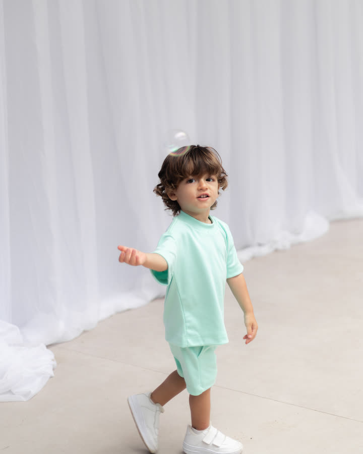 Criança andando com o Conjunto Oversize Banim, cor Verde Água